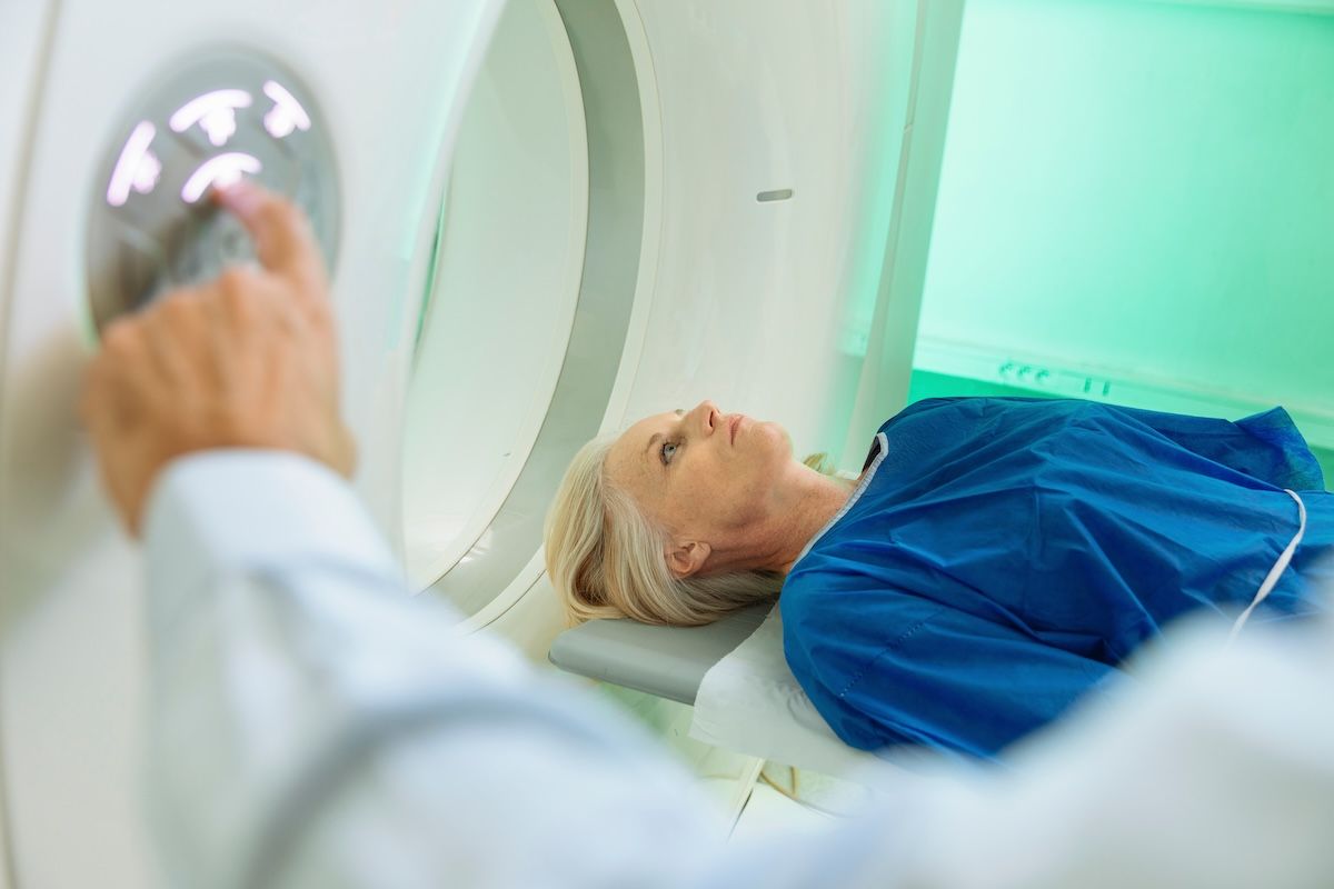 Woman in a medical scanner with a guiding red laser line.